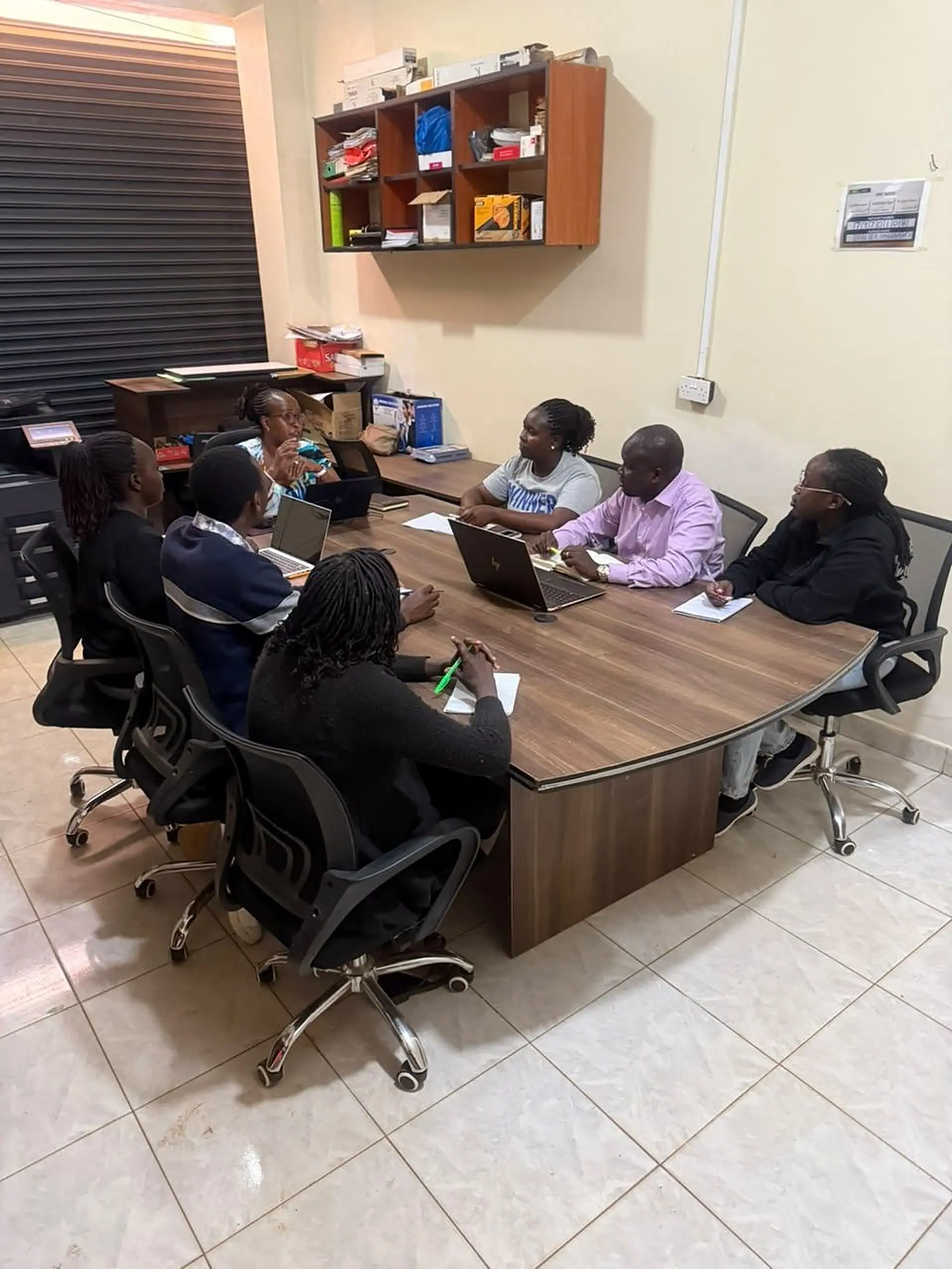 The Kerada team in a meeting around the boardroom table at the Eldoret office