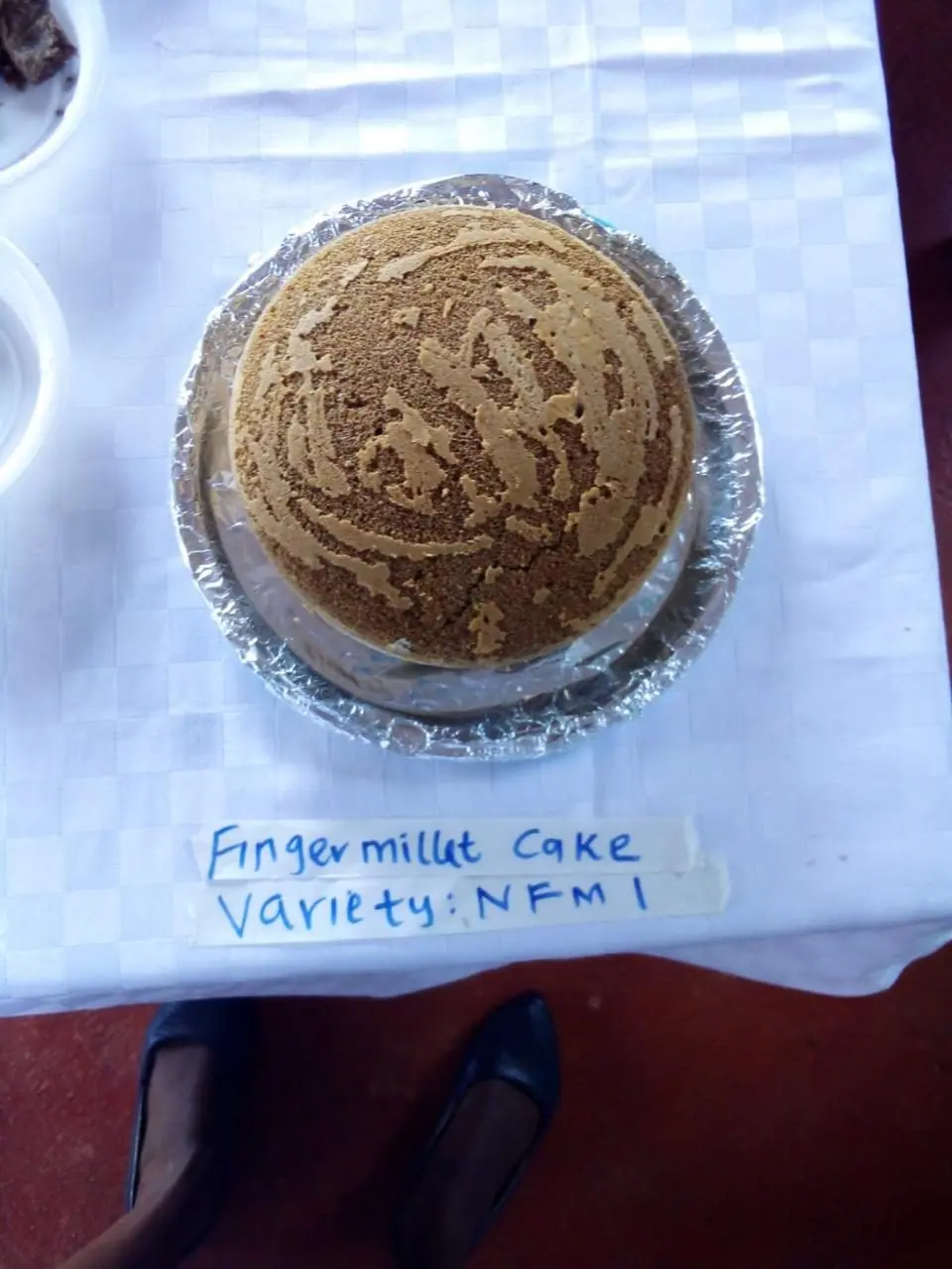 A finger millet cake sample labelled variety NFM1 during a food product trial