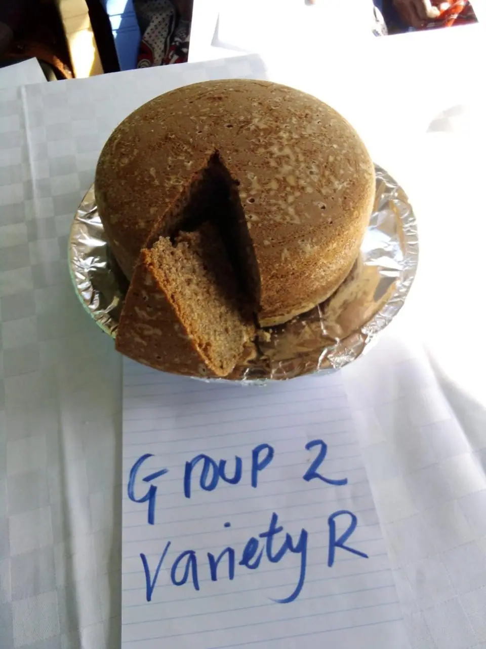 A finger millet cake sample cut open to show the crumb, labelled Group 2 variety R