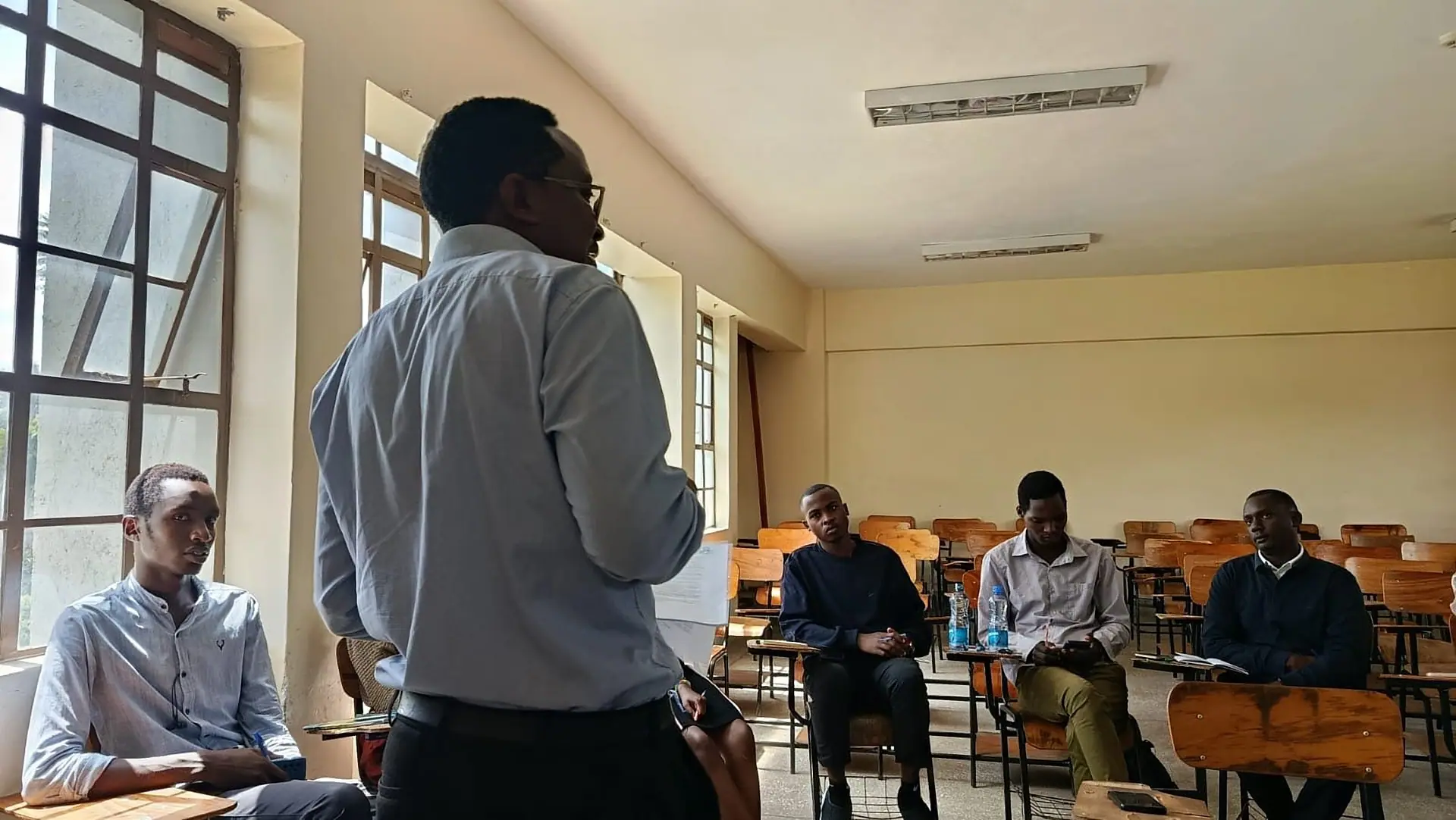 A Kerada researcher briefing field enumerators in a university lecture room ahead of a household survey